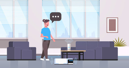 housewife using smart speaker voice recognition controlling vacuum cleaner housework concept modern living room interior flat horizontal full length
