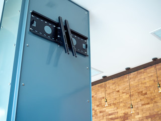 Black TV wall mount on blue steel pillar