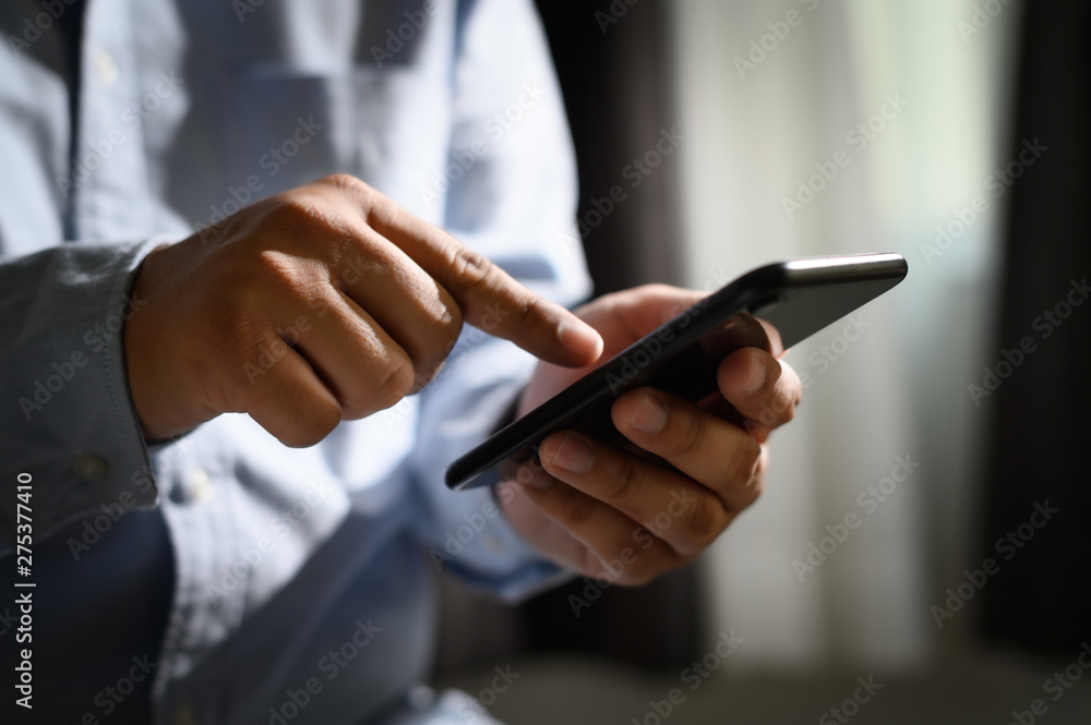 Poster man holding en hands and using digital tablet mobile phone telephone with blank copy space scree