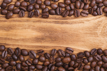 Coffee bean. The background of roasted coffee beans is brown on wooden boards. layout. Flat lay.