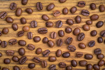 Coffee bean. The background of roasted coffee beans is brown on wooden boards. layout. Flat lay.
