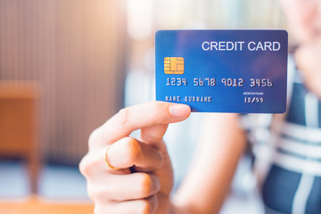 Business woman hand holds a blue credit card.