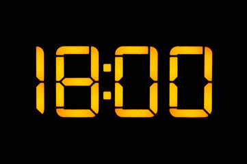 Electronic digital clock with orange numbers on a black background shows the time. Eighteen zero...