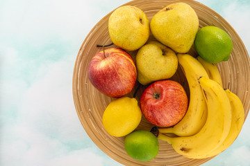 Fruits on a Plate. Apples, Pears, Bananas, Lemon, and Limes. Top View, Copy Space