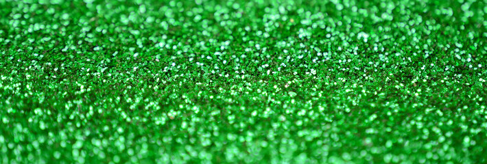 A huge amount of green decorative sequins. Background image with shiny bokeh lights from small...