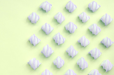 Colorful marshmallow laid out on lime paper background. pastel creative textures