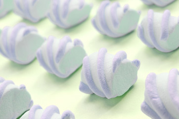 Colorful marshmallow laid out on lime paper background. pastel creative textured pattern
