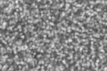 Blurred silver decorative sequins. Background image with shiny bokeh lights from small elements