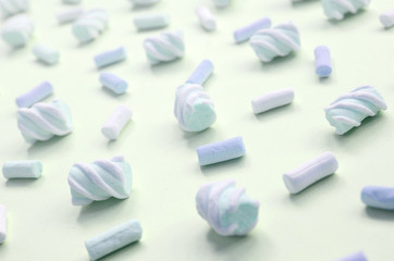 Colorful marshmallow laid out on lime paper background. pastel creative textured pattern