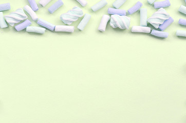Colorful marshmallow laid out on lime paper background. pastel creative textured framework