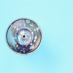 Used spray can with blue paint drips lie on texture background of fashion pastel blue color paper