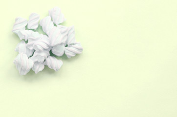 Colorful marshmallow laid out on lime paper background. pastel creative texture