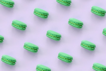 Green dessert cake macaron or macaroon on trendy pastel lilac background top view