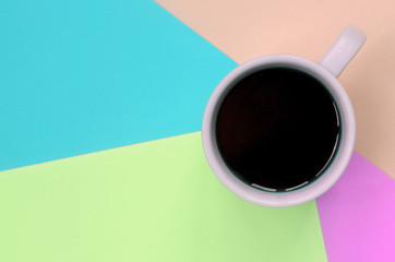 Small white coffee cup on texture background of fashion pastel pink, blue, coral and lime colors...