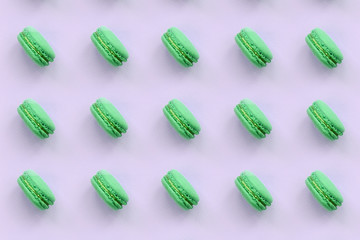 Green dessert cake macaron or macaroon on trendy pastel lilac background top view