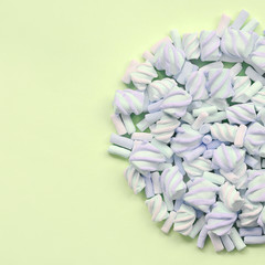 Colorful marshmallow laid out on lime paper background. pastel creative texture