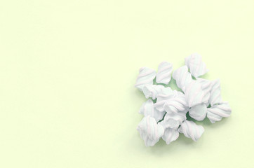 Colorful marshmallow laid out on lime paper background. pastel creative texture