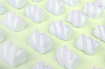 Colorful marshmallow laid out on lime paper background. pastel creative textured pattern