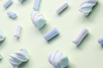 Colorful marshmallow laid out on lime paper background. pastel creative textured pattern