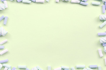 Colorful marshmallow laid out on lime paper background. pastel creative textured framework