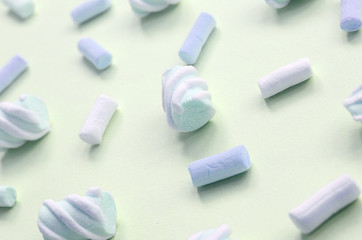 Colorful marshmallow laid out on lime paper background. pastel creative textured pattern