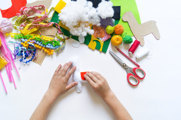 The hands of the child diy do handicraft toy lama. Felt soft craftsmanship.