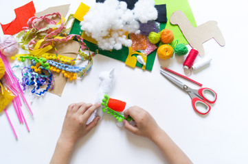 The hands of the child diy do handicraft toy lama. Felt soft craftsmanship.