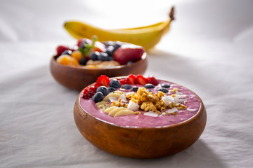 Smoothie bowl with fruits in wooden bowl