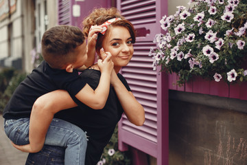 Family in a summer city. Mother in a black t-shirt. Cute little boy