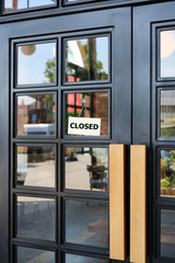 Closed sign board hanging on door of cafe.