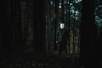 Fototapeta premium Killer with mask and sword in the forest dark horror background