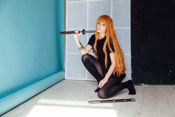 young woman in japanese anime cosplay, holding samurai sword.