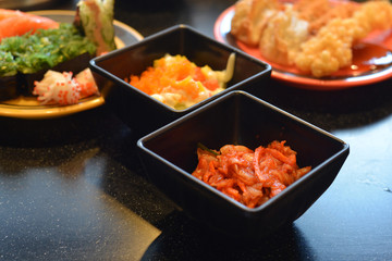 Spicy kimchi salad and Sushi, Asian food assortment.