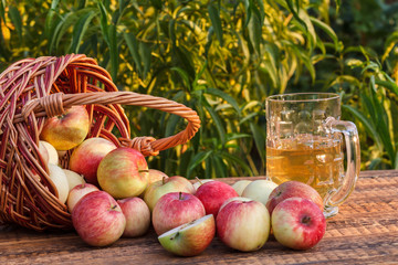Just picked apples in a wicker basket and apple cider in glass goblet