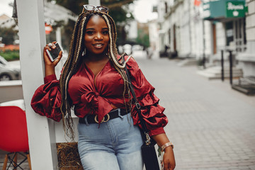 Cute black woman have fun in a city. Beautiful black girl in a red blouse