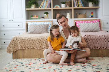 Caucasian dad with two children reading book