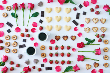 Top view of heart shaped chocolate and cookies, roses, strawberry and coffee over white background. St Valentines or Women day concept. 