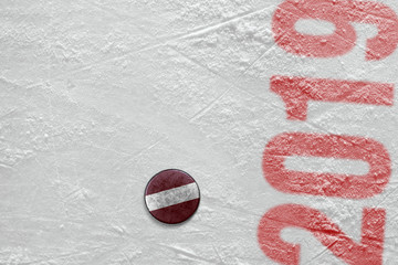 Hockey puck with the image of the Swiss flag, lying on the ice of the arena