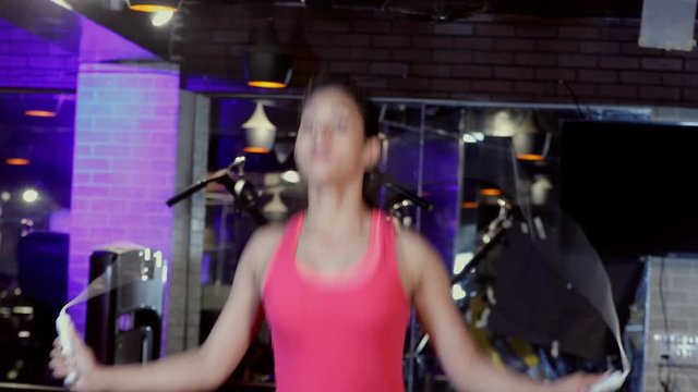Shot of a young female skipping rope in a gym