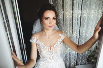 Fototapeta premium Beautiful bride style. Wedding girl stand in luxury wedding dress near window