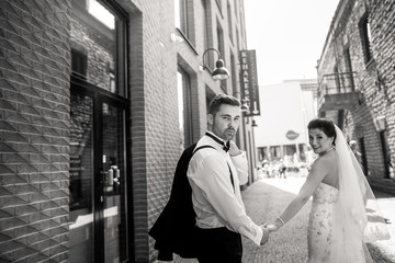 Bride and groom walking in the city, wedding day, marriage concept. Bride and groom in urban...