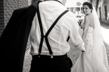 Bride and groom walking in the city, wedding day, marriage concept. Bride and groom in urban background. young couple in wedding day.