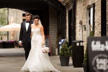 Bride and groom walking in the city, wedding day, marriage concept. Bride and groom in urban...