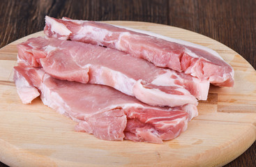 Pork steaks on a wooden cutting board. Raw pork meat for steaks.
