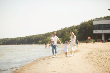 Smiling parents with children at sea. Happy family with two children enjoying summer holiday at beach in Estonia, Tallinn