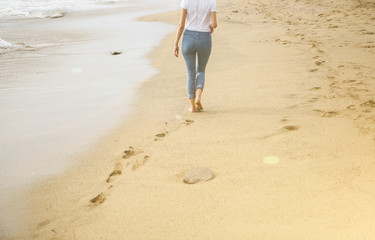 Hipster girl is walking at the beach.Beautiful sea view. Big waves at the oceanside. Coastline with...