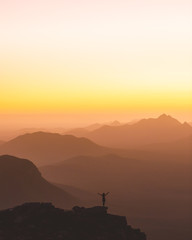 woman silhouette on mountain at sunset
