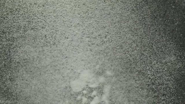 Fine powdered salt moving rhythmically through sound on a light surface.