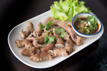 Thai-style deep-fried pork intestine with sweet black soy sauce, served in plastic plate by side of rice