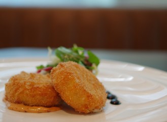 crispy fried croquettes potato beef meat korokke with sauce on white plate with vegetable
